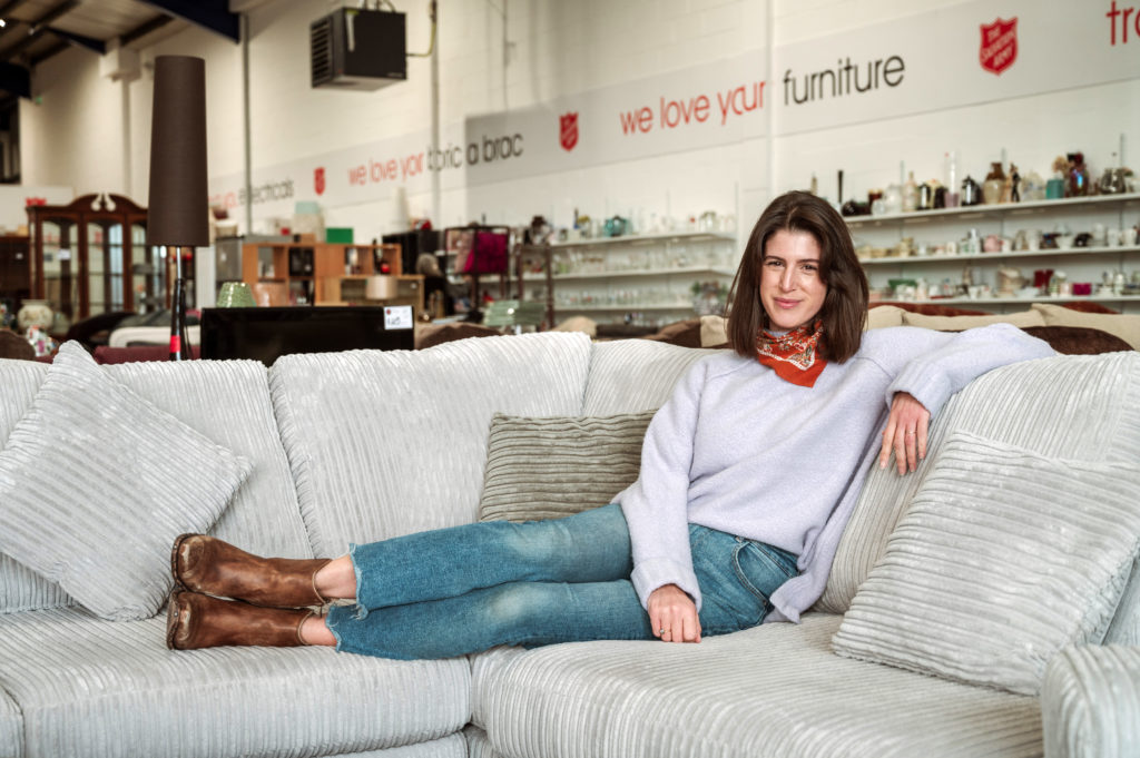 Influencer @Thankfifi sitting on a sofa inside the Salvation Army's Renfrew donation centre