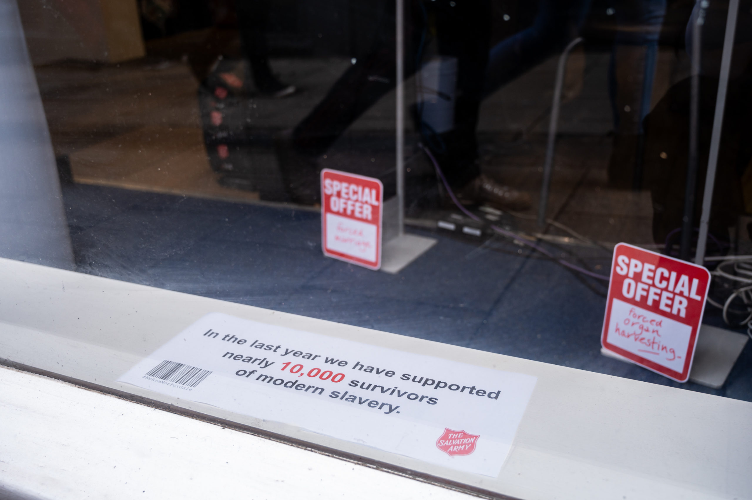 window display showing a piece of paper on the window sill, with information about number of modern day slavery victims