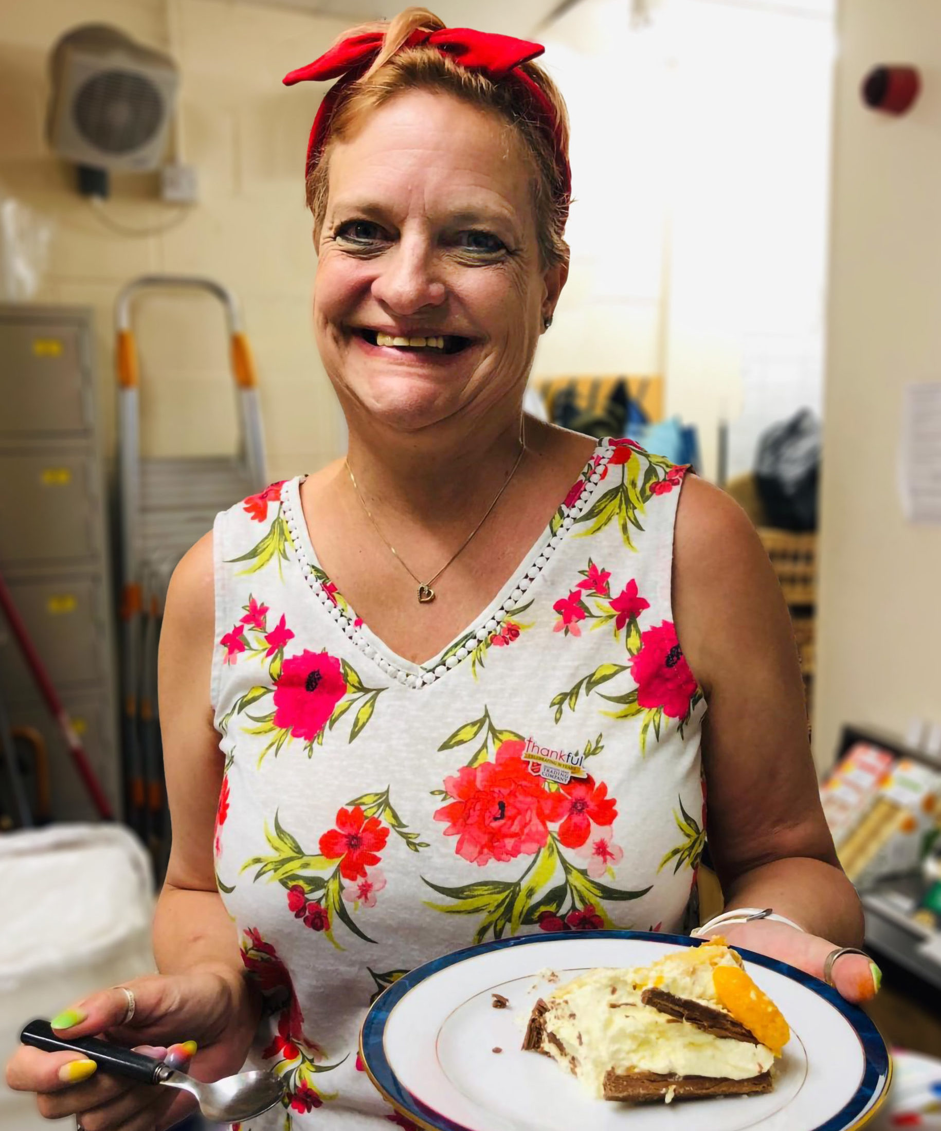 Smiling Salvation Army volunteer holding plate with cake on.