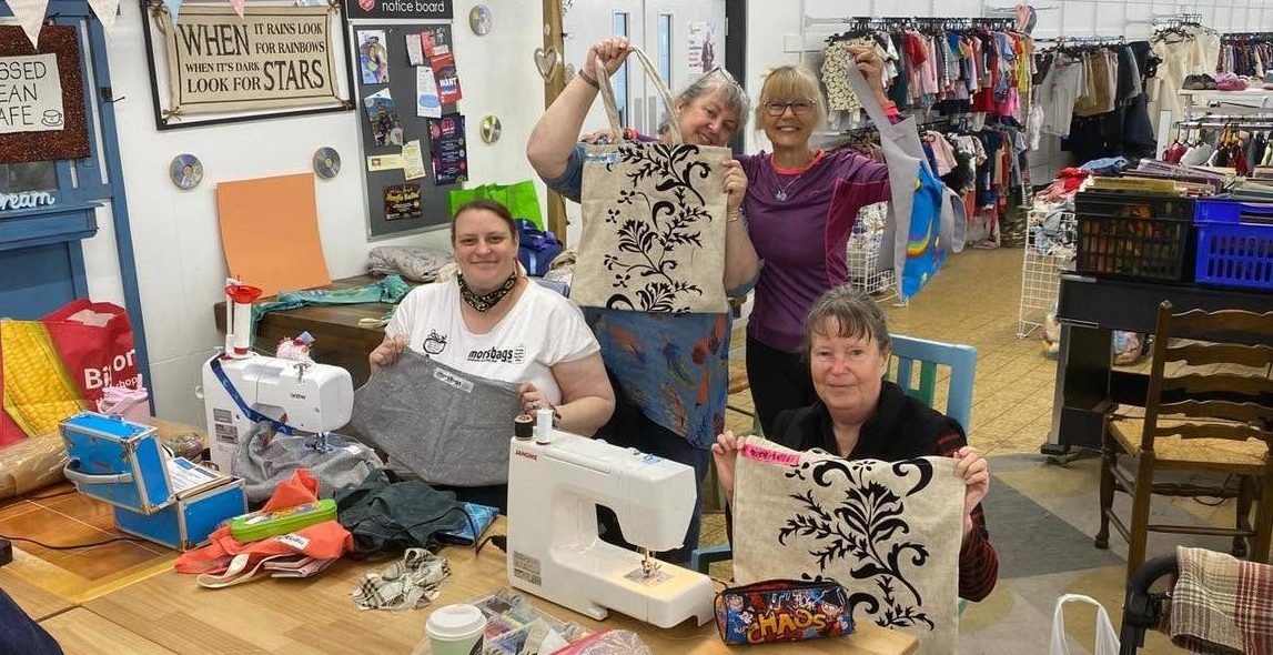 Morsbags volunteers holding upcycled tote nags in Salvation Army Chilwell Donation Centre