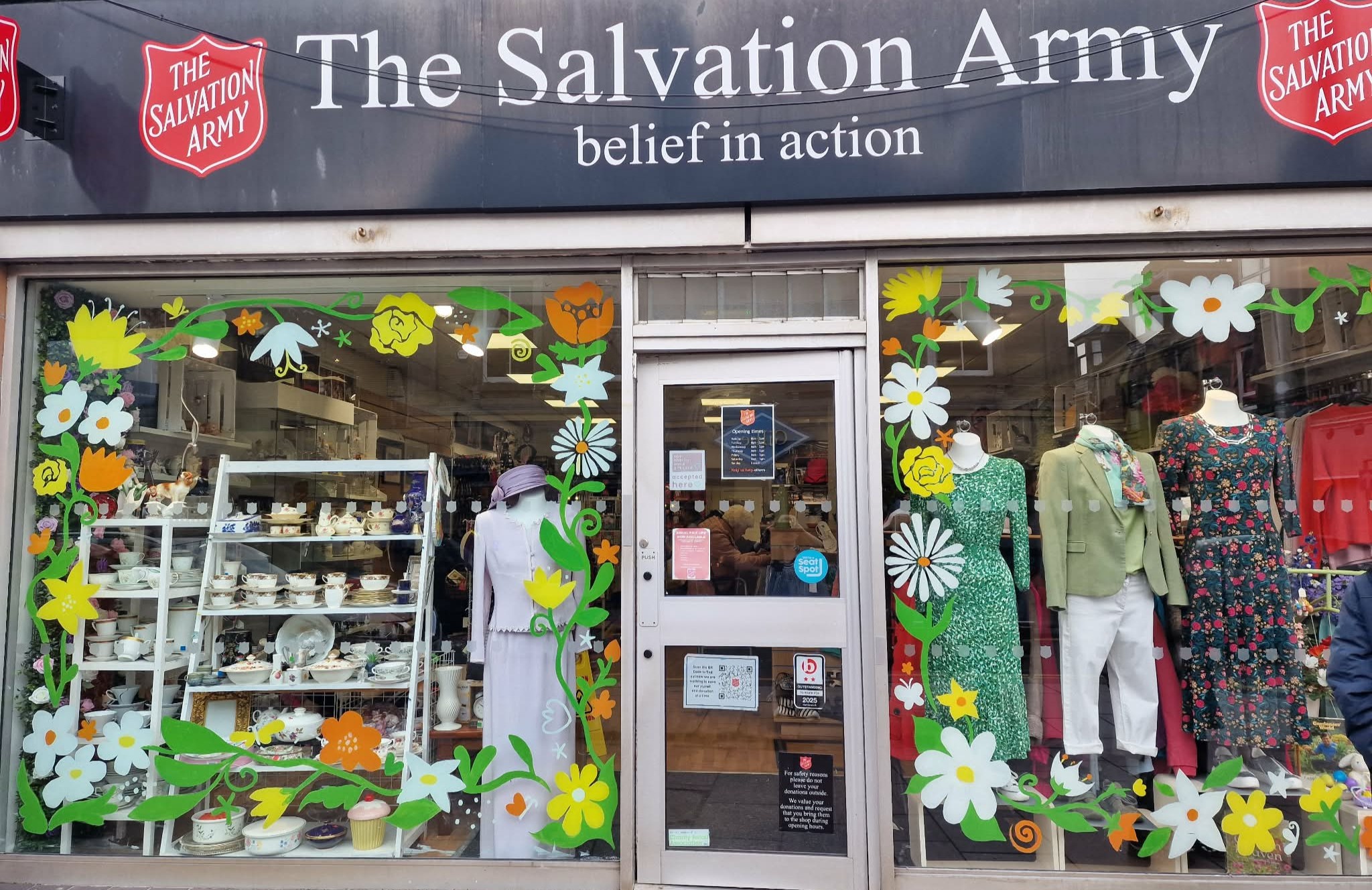 Salvation Army Broughty Ferry Charity shop window featuring spring flowers and colourful outfits