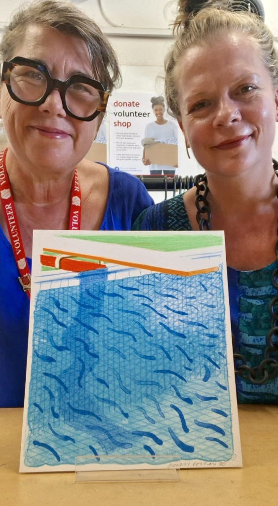 Salvation Army Norwich charity shop volunteer, Jemma Banks, and Manager Maria Zacharias, with the rare David Hockney book
