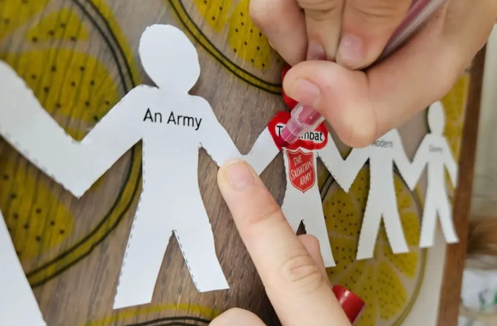 Paperchain featuring with figures of people holding hands, with Salvation Army shield in the middle